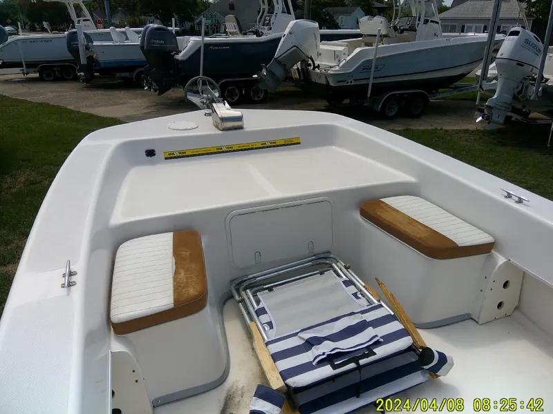 Slide: The Image of 2015 Sundance B22CCR boat interior with seating and striped towel, surrounded by other boats. - 10