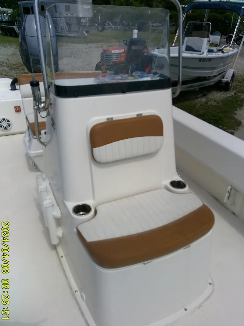 Slide: The Image of 2015 Sundance B22CCR boat with cushioned seating and console, docked outdoors. - 11