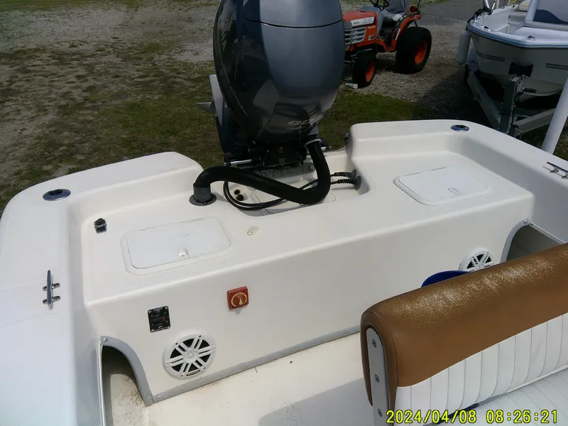 Slide: The Image of 2015 Sundance B22CCR boat with motor, white deck, and brown seating. - 14