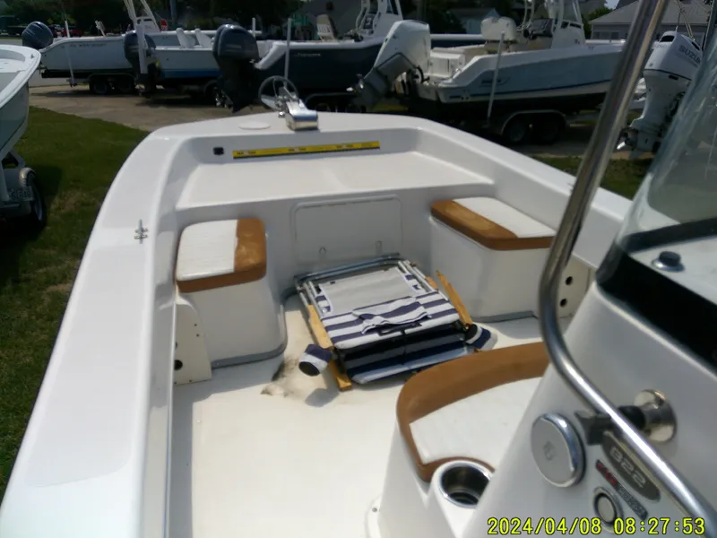 Slide: The Image of 2015 Sundance B22CCR boat interior with seating and equipment, displayed outdoors. - 18