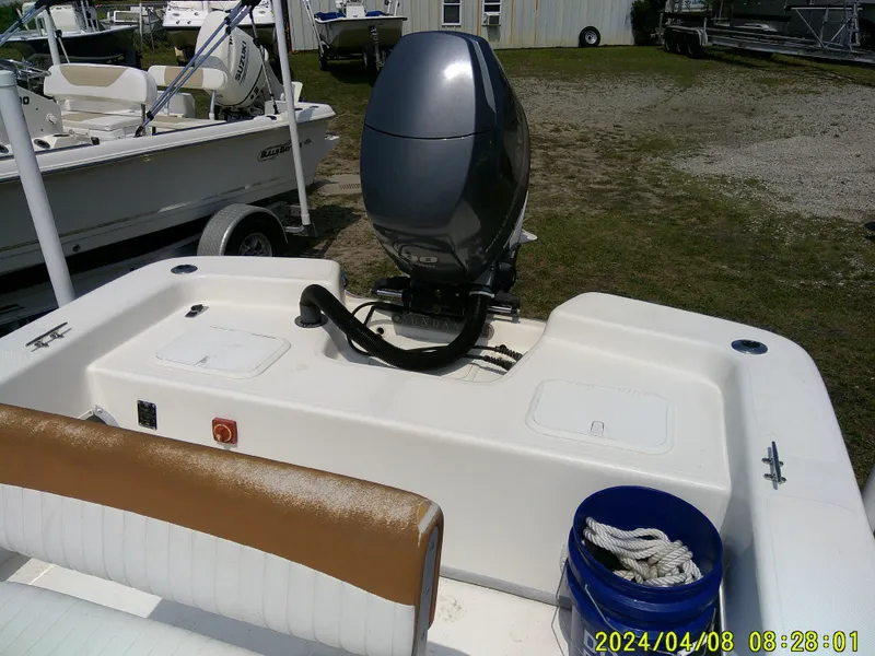 Slide: The Image of 2015 Sundance B22CCR boat with outboard motor and seating, parked outdoors. - 20