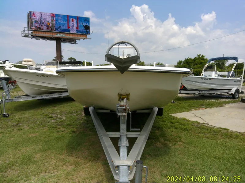 Slide: The Image of Sundance B22CCR boat on trailer, grassy area, clear sky, billboard in background. - 3