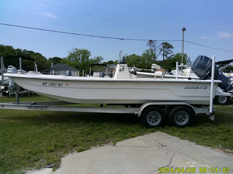 Slide: The Image of 2015 Sundance B22CCR boat on trailer, parked outdoors under clear sky. - 5