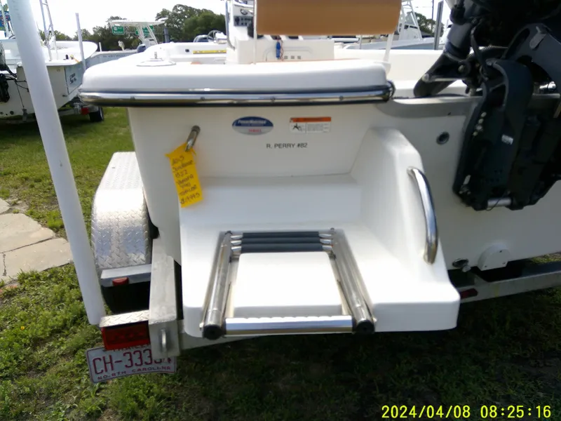 Slide: The Image of Sundance B22CCR 2015 boat with rear ladder and motor, parked on a trailer. - 9