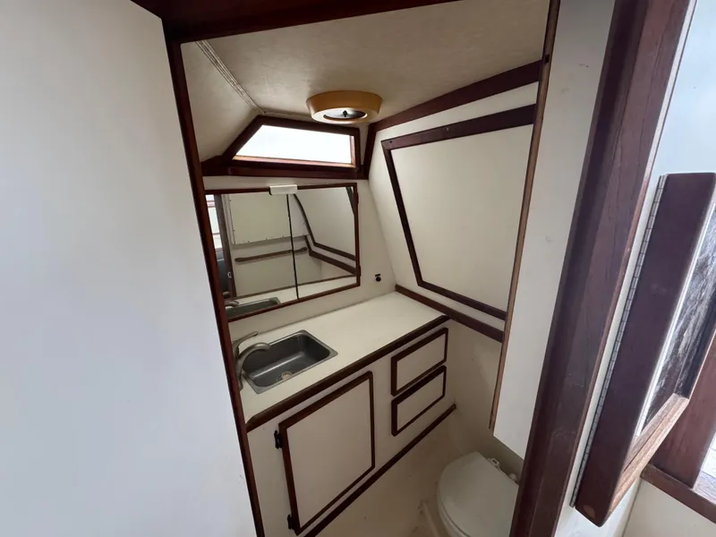 Slide: The Image of 1985 Blackfin 29 Combi Express boat bathroom with sink, mirror, and toilet. - 10