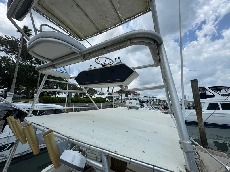 Slide: The Image of 1985 Blackfin 29 Combi Express boat docked, featuring upper deck and fishing rod holders. - 14