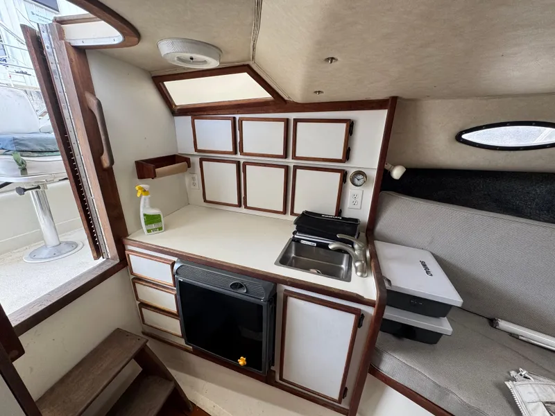 Slide: The Image of 1985 Blackfin 29 Combi Express cabin interior with kitchenette and seating area. - 9