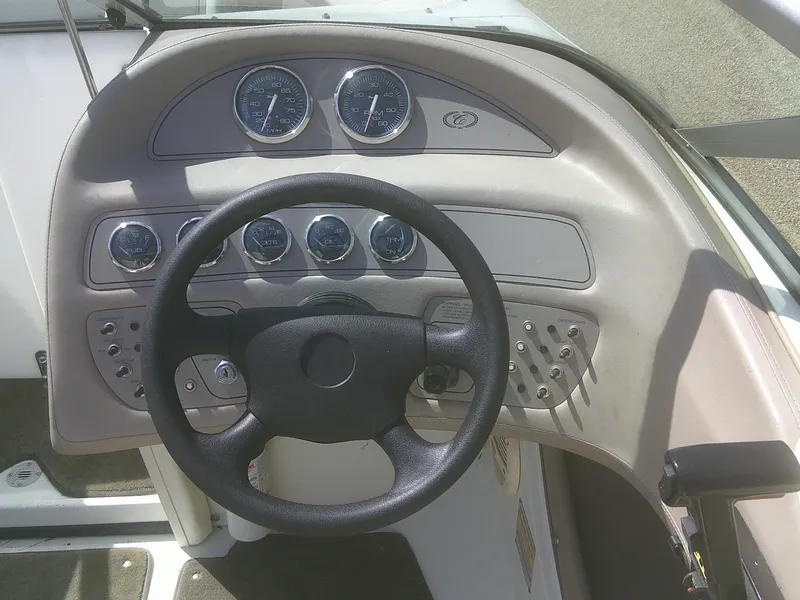 Slide: The Image of Steering wheel and dashboard of a 1998 Cobalt 220 boat, featuring multiple gauges and controls. - 10