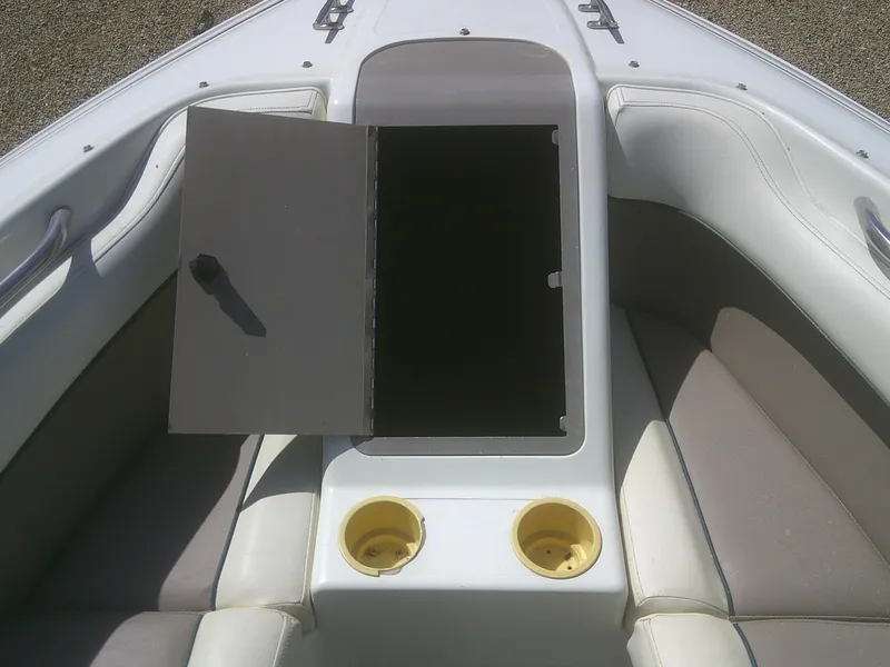 Slide: The Image of 1998 Cobalt 220 boat interior with open storage compartment and cup holders. - 7