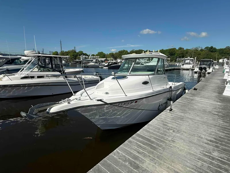 Slide: The Image of 2005 Seaswirl Striper 2601 Walkaround O/B docked at a marina under clear skies. - 2