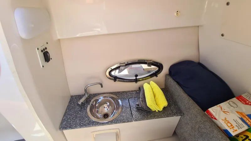 Slide: The Image of 2018 Chaparral Suncoast 250 Deluxe interior with sink, countertop, and porthole window. - 14