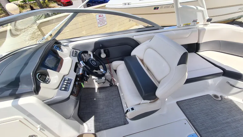 Slide: The Image of 2018 Chaparral Suncoast 250 Deluxe boat interior with steering wheel and seating area. - 18
