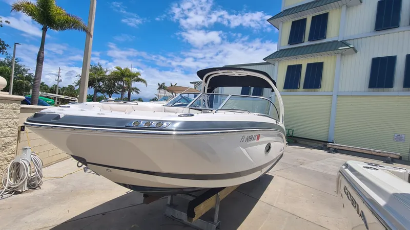 Slide: The Image of 2018 Chaparral Suncoast 250 Deluxe boat docked under a clear blue sky. - 2