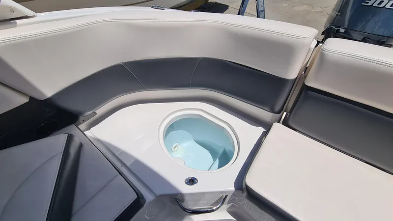 Slide: The Image of 2018 Chaparral Suncoast 250 Deluxe boat interior with seating and built-in cooler. - 20