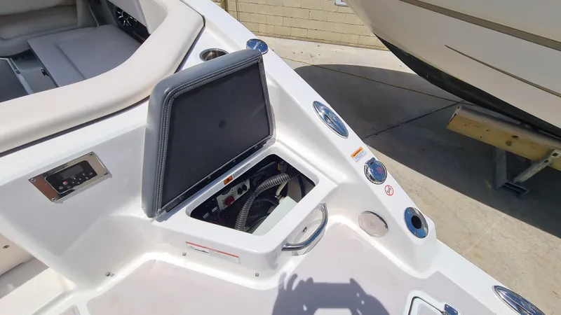 Slide: The Image of 2018 Chaparral Suncoast 250 Deluxe boat dashboard with control panel and storage compartment. - 22