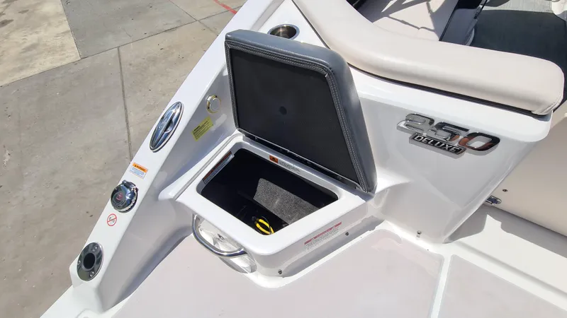 Slide: The Image of 2018 Chaparral Suncoast 250 Deluxe boat storage compartment with open lid and control panel. - 24