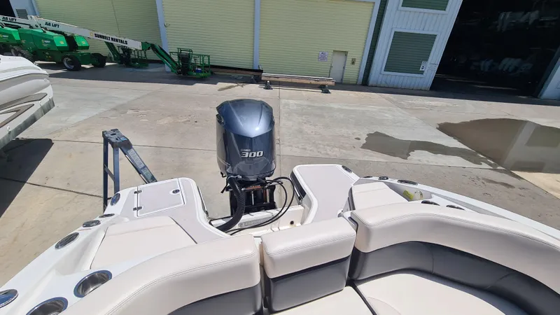 Slide: The Image of 2018 Chaparral Suncoast 250 Deluxe boat with powerful outboard motor in a marina setting. - 31