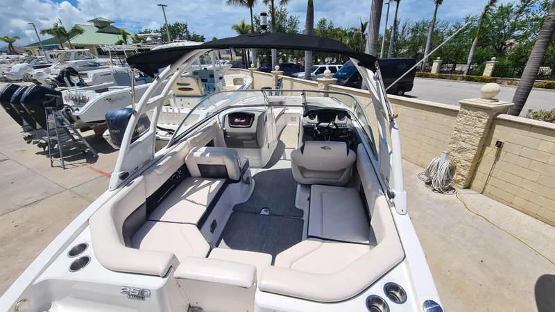 Slide: The Image of 2018 Chaparral Suncoast 250 Deluxe boat with spacious seating and canopy, docked outdoors. - 33