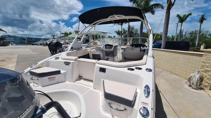 Slide: The Image of 2018 Chaparral Suncoast 250 Deluxe boat with seating, docked under a sunny sky. - 34