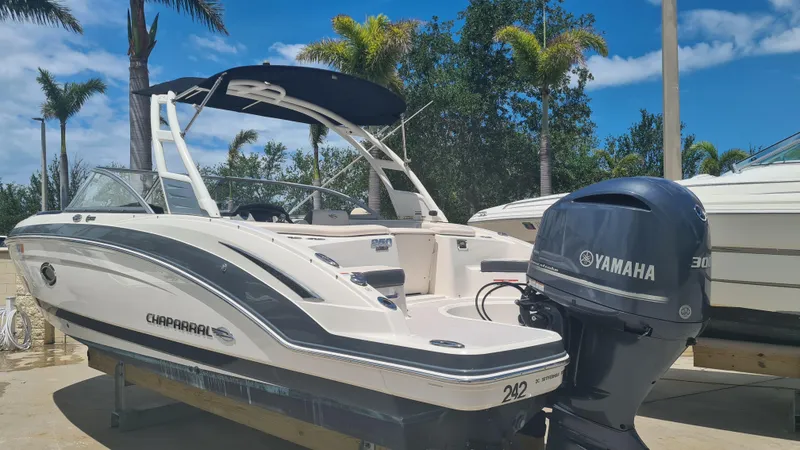 Slide: The Image of 2018 Chaparral Suncoast 250 Deluxe boat with Yamaha engine, docked under clear skies. - 4