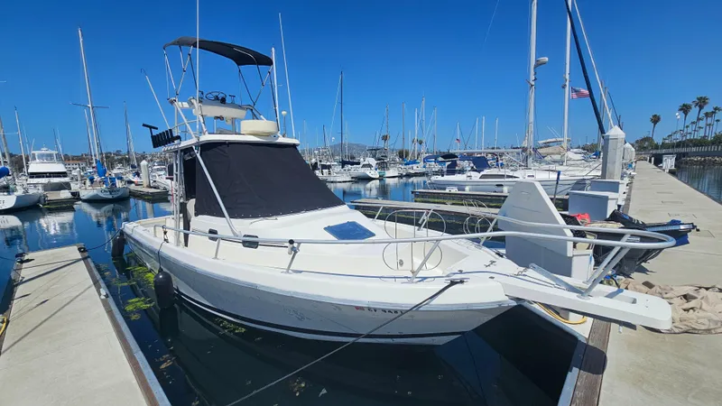 The Image of 1992 Luhrs Tournament 300 boat docked in a marina under clear blue skies. - 0