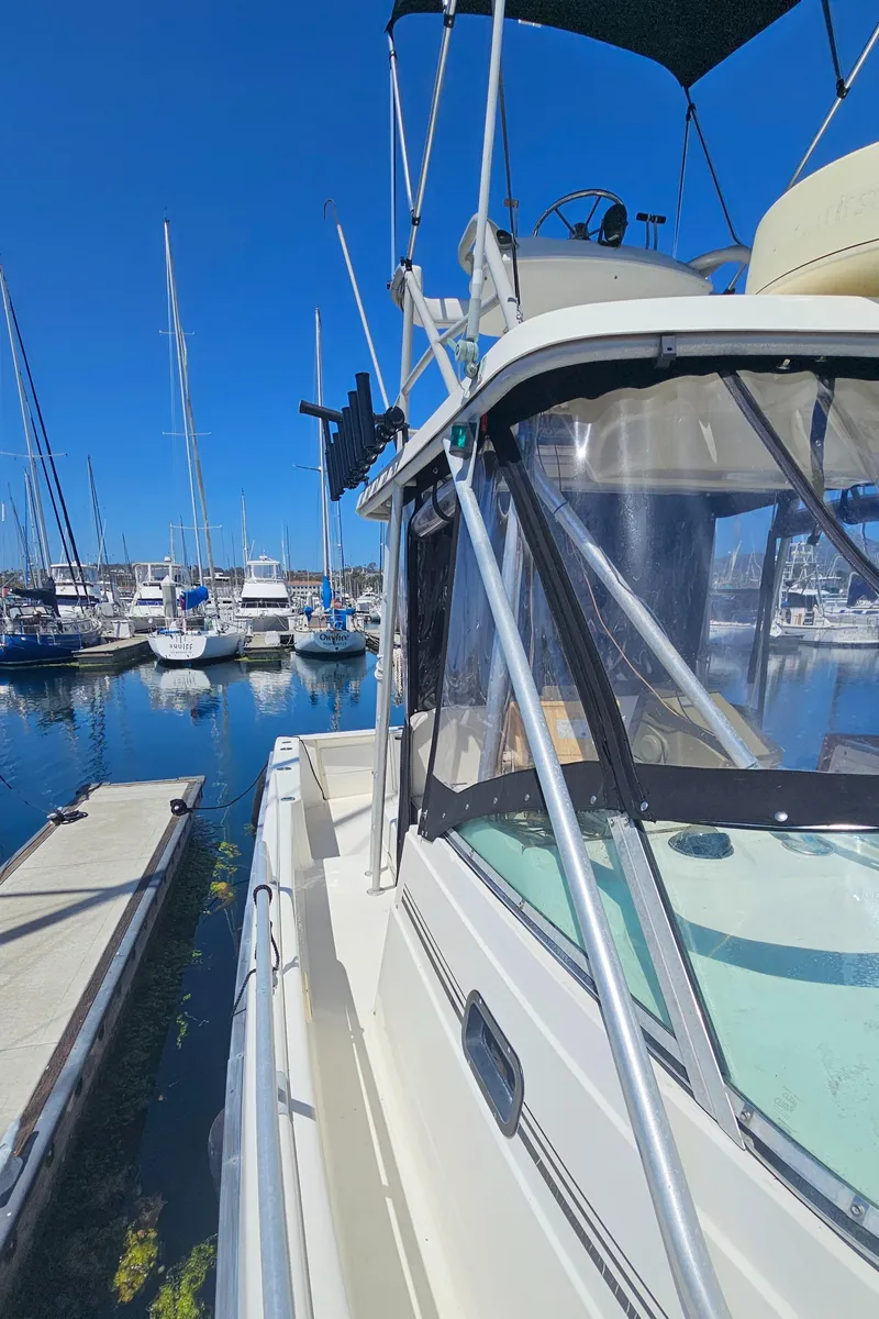 Slide: The Image of 1992 Luhrs Tournament 300 boat docked at marina under clear blue sky. - 11