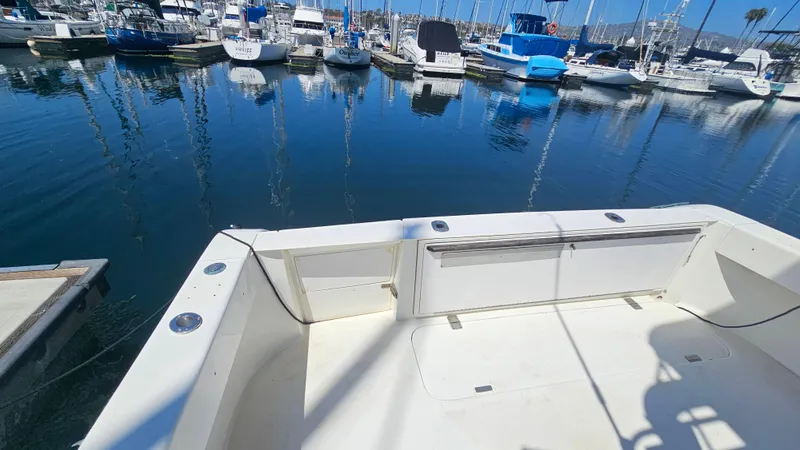 Slide: The Image of 1992 Luhrs Tournament 300 boat docked in a marina with calm water and other boats. - 12