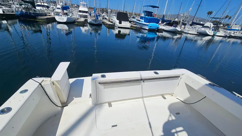 Slide: The Image of 1992 Luhrs Tournament 300 boat docked in a marina with other vessels. - 13