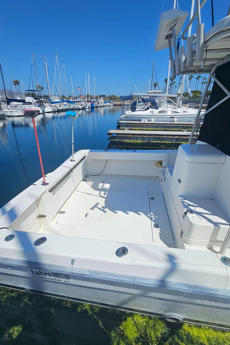 Slide: The Image of 1992 Luhrs Tournament 300 boat docked in a marina under clear blue skies. - 14