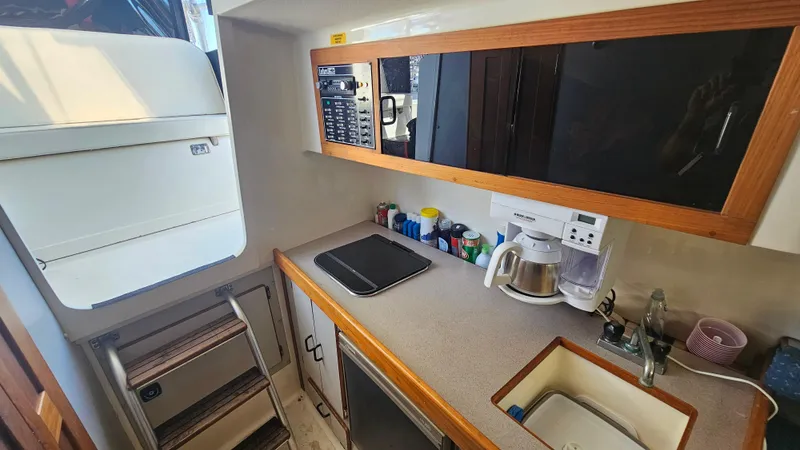 Slide: The Image of 1992 Luhrs Tournament 300 galley with sink, stove, and storage cabinets. - 22