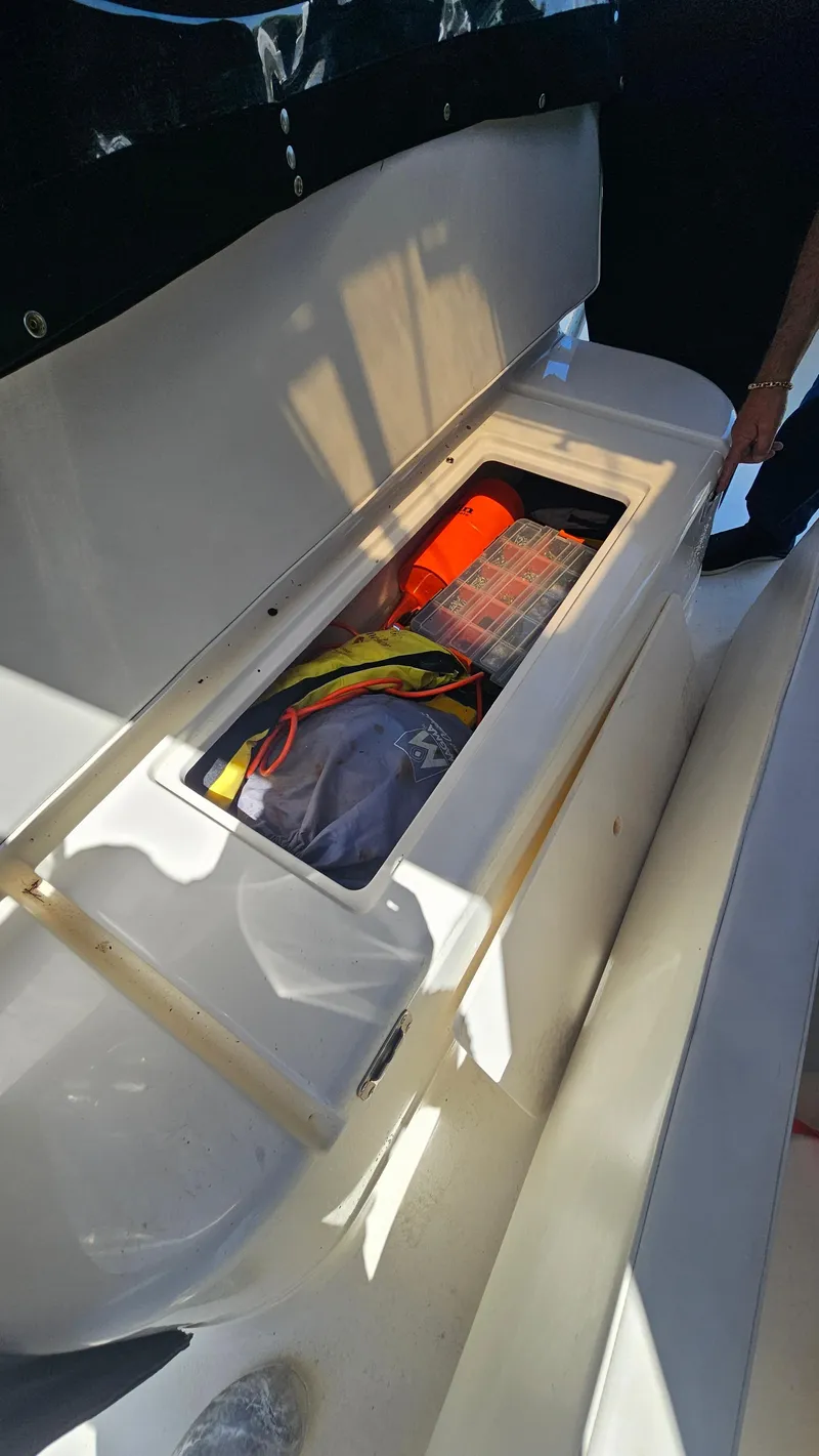 Slide: The Image of Open storage compartment on 1992 Luhrs Tournament 300 boat, containing safety gear and equipment. - 25