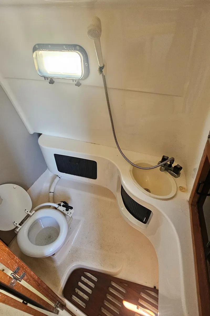 Slide: The Image of 1992 Luhrs Tournament 300 boat bathroom with toilet, sink, and showerhead. - 27