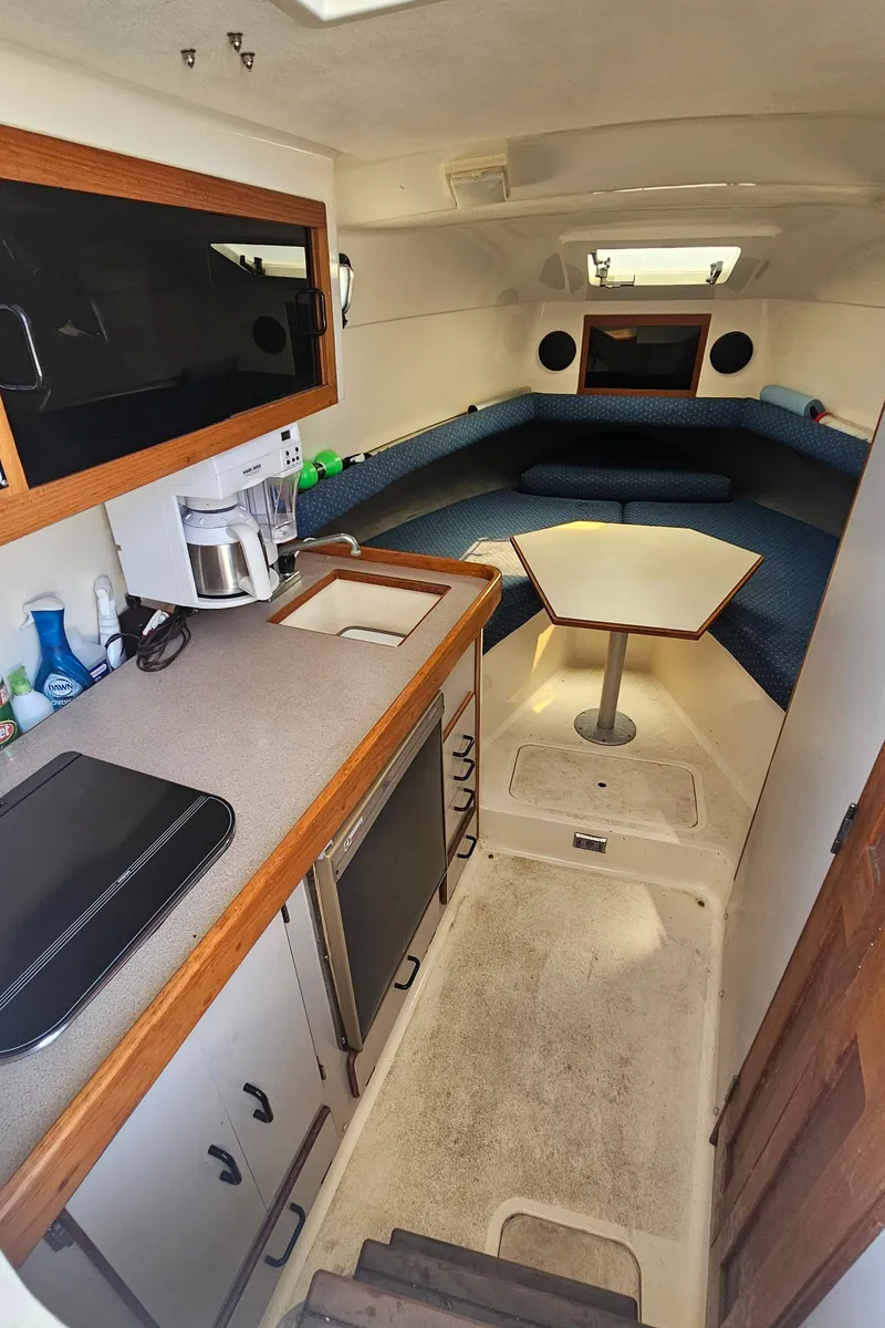 Slide: The Image of 1992 Luhrs Tournament 300 cabin interior with kitchenette, seating area, and table. - 28