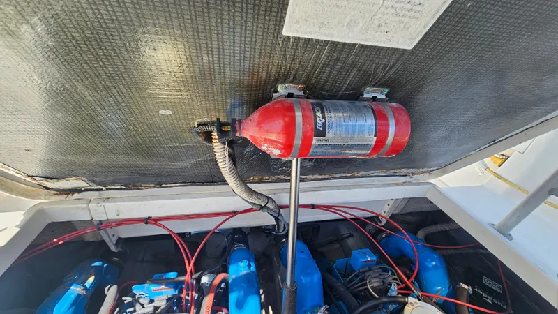 Slide: The Image of Engine compartment of a 1992 Luhrs Tournament 300 with fire extinguisher and wiring visible. - 29