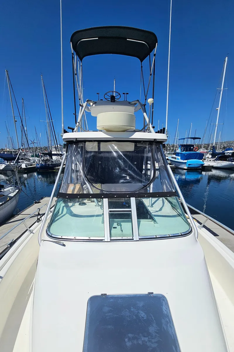 Slide: The Image of 1992 Luhrs Tournament 300 boat docked in a marina under clear blue skies. - 3