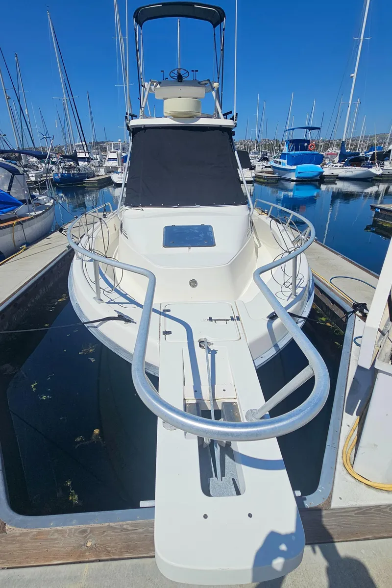 Slide: The Image of 1992 Luhrs Tournament 300 boat docked in a marina, surrounded by other vessels. - 4