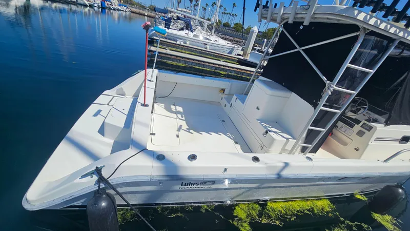 Slide: The Image of 1992 Luhrs Tournament 300 boat docked in marina, featuring spacious deck and sleek design. - 6