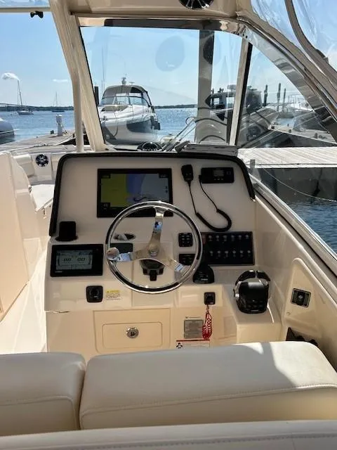 Slide: The Image of 2020 Grady-White Freedom 325 boat helm with modern controls and waterfront view. - 20