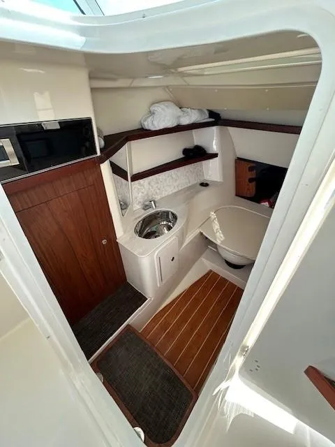 Slide: The Image of 2020 Grady-White Freedom 325 boat interior with sink, toilet, and wooden accents. - 21