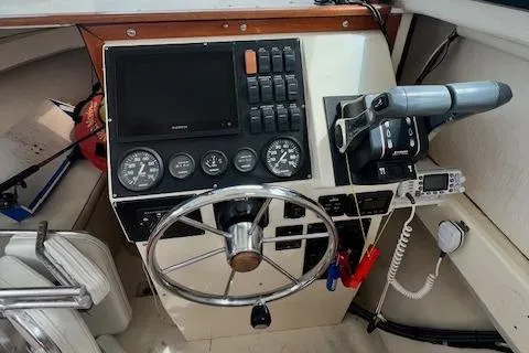 Slide: The Image of 1989 Parker 2520 Modified Vee Sport Cabin helm with steering wheel and control panel. - 2