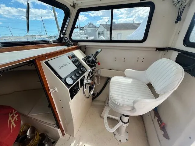 Slide: The Image of 1989 Parker 2520 Modified Vee Sport Cabin interior with steering wheel and Garmin navigation system. - 3