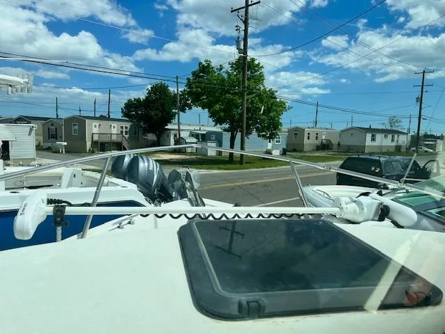 Slide: The Image of 1989 Parker 2520 Modified Vee Sport Cabin boat in a residential area, under a blue sky. - 8