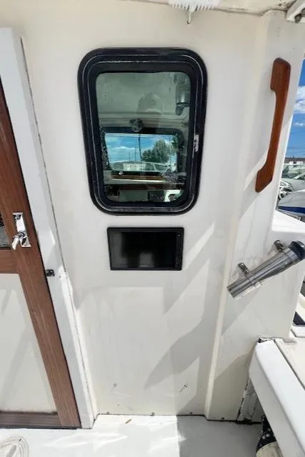 Slide: The Image of 1989 Parker 2520 Modified Vee Sport Cabin boat interior with window and seating. - 9