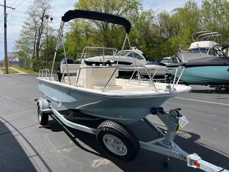 Slide: The Image of 2022 Boston Whaler 150 Montauk boat on trailer, parked outdoors. - 3