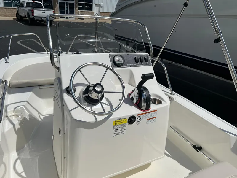 Slide: The Image of 2022 Boston Whaler 150 Montauk boat console with steering wheel and controls. - 6
