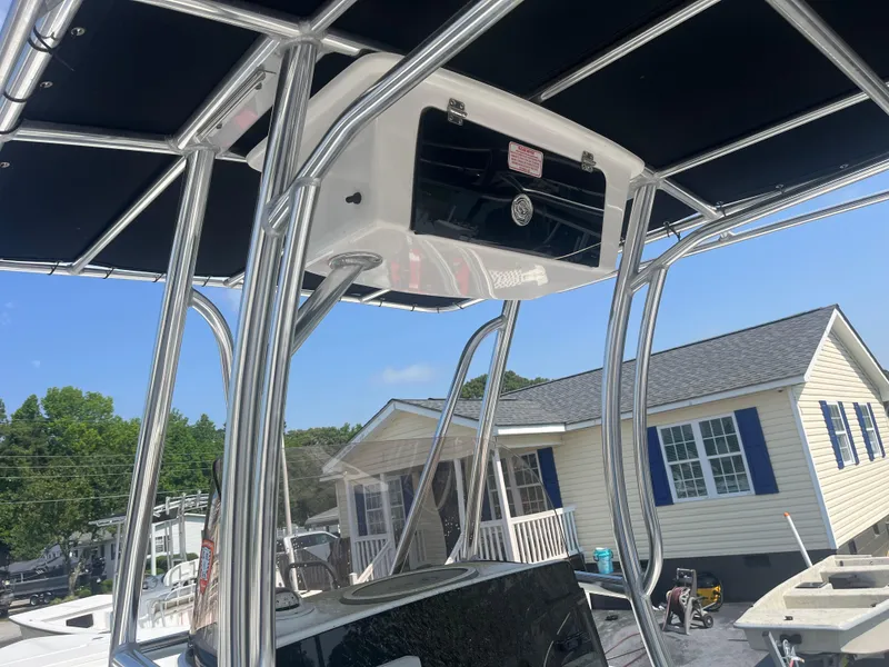 Slide: The Image of 2018 Sea Hunt Triton 225 boat with T-top, parked near a house. - 10