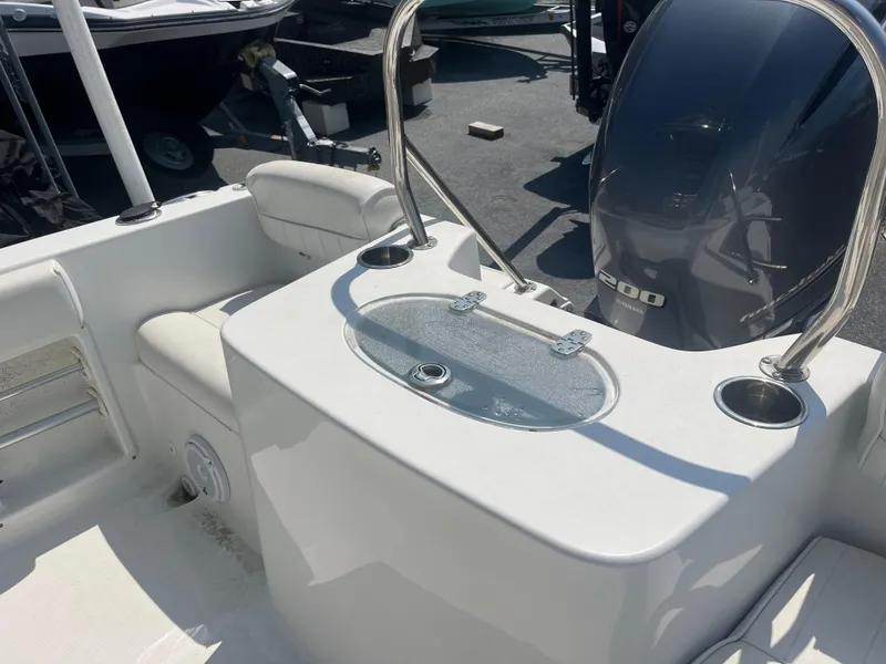 Slide: The Image of 2018 Sea Hunt Triton 225 boat interior with seating and motor. - 11