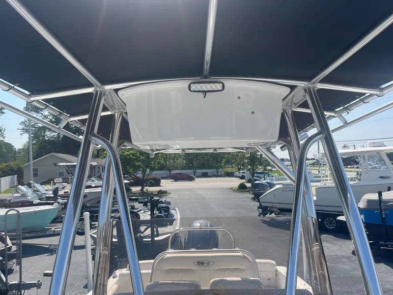 Slide: The Image of 2018 Sea Hunt Triton 225 boat with T-top, parked in a marina. - 6