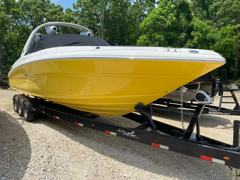 Slide: The Image of 2004 Sea Ray 290 SLX boat with a vibrant yellow hull on a trailer. - 1