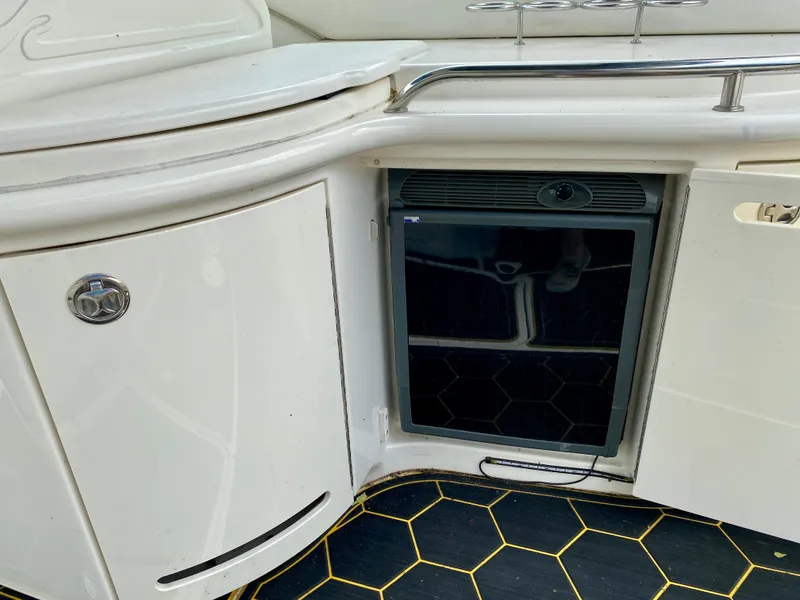 Slide: The Image of 2004 Sea Ray 290 SLX boat interior with mini fridge and storage cabinet. - 10